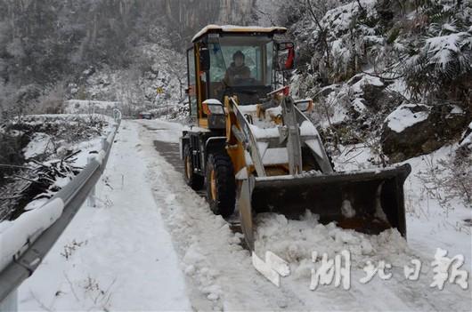 覃俊芳驾驶自家铲车在马鞍山村的山路上铲雪。 通讯员 张晓灵 摄